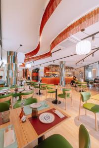 a dining room with tables and green chairs at Hotel El Nogal in Peligros
