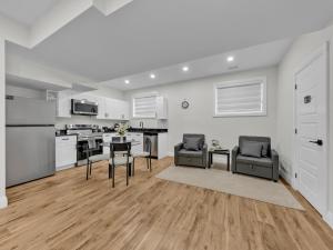 a kitchen with white cabinets and a table and chairs at Windsor Perfect Stay in Windsor +25 photos