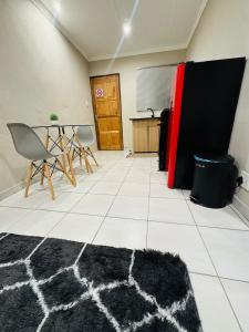 a room with a table and a red refrigerator at Hei Stays One Bed Apartment in Bronkhorstspruit