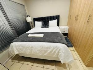 a bedroom with a large bed with a black headboard at Hei Stays One Bed Apartment in Bronkhorstspruit