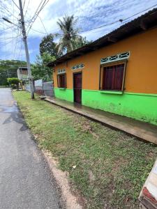 a yellow and green house on the side of a street at Hostal Sol Naciente in Rivas