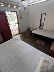 a room with two beds and a door and a window at Hostal Sol Naciente in Rivas