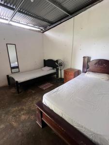 a bedroom with a bed and a bench in it at Hostal Sol Naciente in Rivas