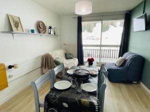 a living room with a table and chairs and a couch at Le Vert Montagne Studio lumineux plein sud in Le Dévoluy +24 photos