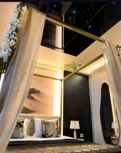a bedroom with a canopy bed with a star ceiling at Hotel Sara & SPA in Prishtinë