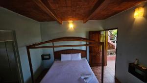 a bedroom with a bed with a wooden canopy at Hotel Casa Huijazoo in Mazunte +40 photos