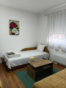 a living room with a bed and a coffee table at Privatni smeštaj Nanica in Mataruška Banja