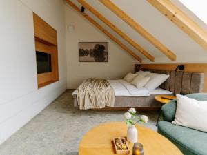 a bedroom with a bed and a couch and a table at Brioni Hills - Premium Escape in Šmarje pri Jelšah