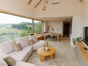 a living room with a white couch and a table at Brioni Hills - Premium Escape in Šmarje pri Jelšah