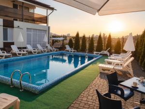 a pool at a hotel with tables and chairs at Vila LOLO in Chişinău