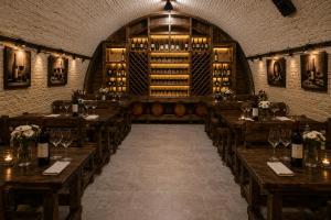 a wine tasting room with wooden tables and wine barrels at Vila LOLO in Chişinău
