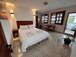 ein Schlafzimmer mit einem Bett, auf dem zwei Blumen liegen in der Unterkunft Los Barranqueros Hotel in Salento