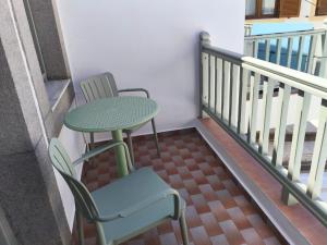 a table and a chair sitting on a balcony at Marea Patmos in Skala