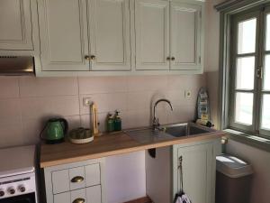 a kitchen with white cabinets and a sink at Marea Patmos in Skala