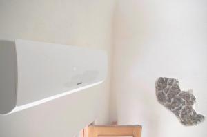 a room with a tv and a rock on the wall at Chibedda Dimora Lia in Acitrezza +29 photos