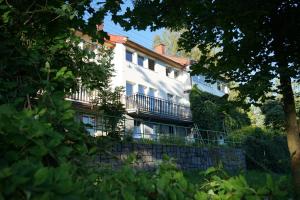 a white building with a balcony on a wall at Studio v Aldrovském Triu in Vítkovice