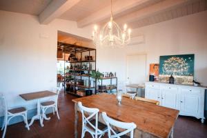 a dining room with a table and chairs and a chandelier at Casale Oliveta & Ristorante in Orbetello
