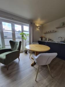 a living room with a table and chairs and a kitchen at Clarke Cottage Guest House in Dunfermline