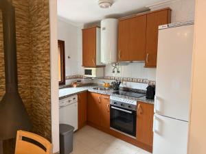 a kitchen with wooden cabinets and a white refrigerator at La escapada in Felechosa