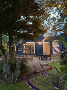 a building with benches and a tree with lights at Lovely garden flat with stunning mountain views in Alcocer