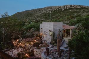 a small house with lights in front of a hill at Lovely garden flat with stunning mountain views in Alcocer