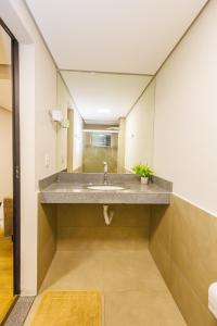 a bathroom with a sink and a mirror at Hotel Move BH in Belo Horizonte