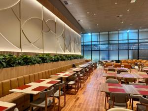 a dining room with tables and chairs and windows at Holiday Inn Sao Paulo Parque Anhembi by IHG in São Paulo