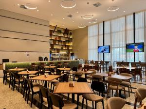 a restaurant with tables and chairs and a tv at Holiday Inn Sao Paulo Parque Anhembi by IHG in São Paulo