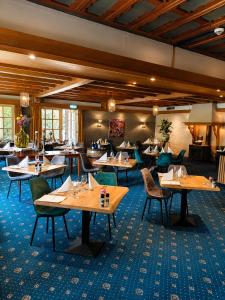 a dining room with wooden tables and chairs at Hotel de Landmarke Ootmarsum in Groot-Agelo