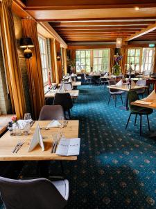 a dining room with tables and chairs and windows at Hotel de Landmarke Ootmarsum in Groot-Agelo +12 photos