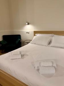 a white bed with towels on it with a chair at Majella vista Mare in Guardiagrele