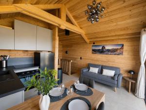 a kitchen and living room with a wooden ceiling at Les 2 Chalets Alpins & Bains Nordiques in Saint-Michel-de-Chaillol