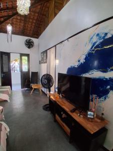 a living room with a large flat screen tv at Garden House - Atins in Atins