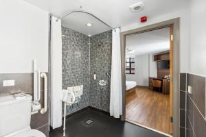 a bathroom with a shower with a toilet and a sink at The Mitre Hotel Brighton in Brighton & Hove +37 photos