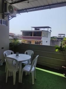 a white table and chairs on a balcony at Hospedaje Blue House - Consulado americano - Habitacion 2 in Guayaquil