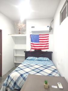 a bedroom with a bed with an american flag on the wall at Hospedaje Blue House - Consulado americano - Habitacion 2 in Guayaquil