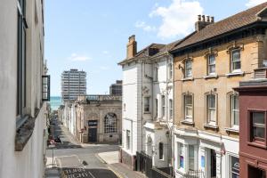 a city street with buildings and the ocean in the background at The Mitre Hotel Brighton in Brighton & Hove