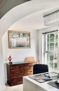 an office with a desk and a dresser and a window at 5-bed house with indoor pool, Jacuzzi &Downs views in Herstmonceux