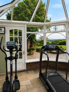 two exercise bikes in front of a house with a window at 5-bed house with indoor pool, Jacuzzi &Downs views in Herstmonceux