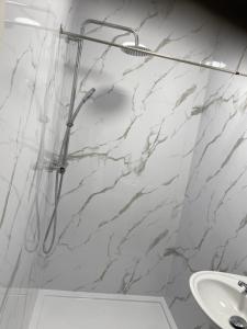 a bathroom with a shower with a white marble wall at 262 Ocean Manor in Blackpool +55 photos