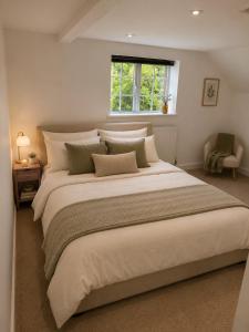 a large bed in a bedroom with a window at 5-bed house with indoor pool, Jacuzzi &Downs views in Herstmonceux +21 photos