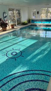 a large swimming pool in a building at 5-bed house with indoor pool, Jacuzzi &Downs views in Herstmonceux