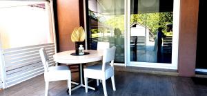 a table and chairs on a porch with a window at LaLuna House in Cernik