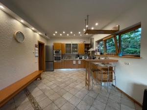 a kitchen with wooden cabinets and a island with bar stools at Just Chill in Riga
