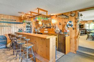 a kitchen with wooden walls and a bar with stools at Dock, Direct Waterfront: Lake Champlain Studio in Willsboro +27 photos