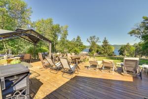 a wooden deck with chairs and tables and a grill at Dock, Direct Waterfront: Lake Champlain Studio in Willsboro