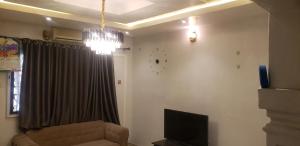a living room with a couch and a clock on the wall at Sejeva in Ikorodu