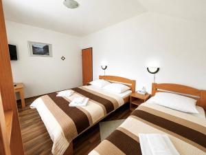 a hotel room with two beds in a room at Guest House Kovačević in Korenica
