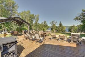 a deck with chairs and tables and a grill at Lake Champlain On-Site! Waterfront Studio w/ Dock in Willsboro