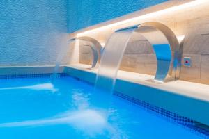 una piscina con dos grifos de agua. en Sallés Hotel Pere IV en Barcelona